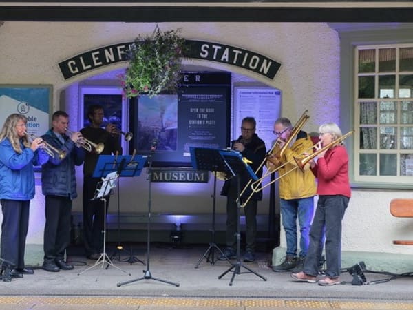 Musicians playing brass instruments in front of the museum